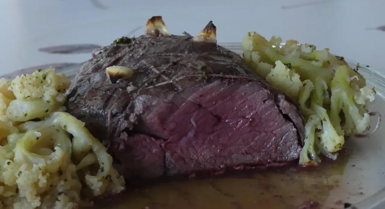 Un rôti de bœuf des Highlands, saignant et tendre, servi avec du chou-fleur rôti aux herbes.