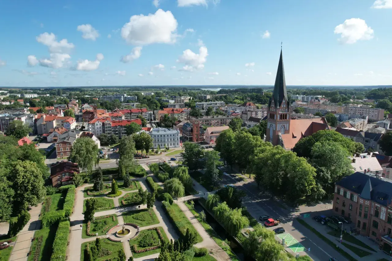 Widok z lotu ptaka na Szczecinek: zabytkowy kościół, zadbany park miejski i urokliwe kamienice. Odkryj szczecinek atrakcje!