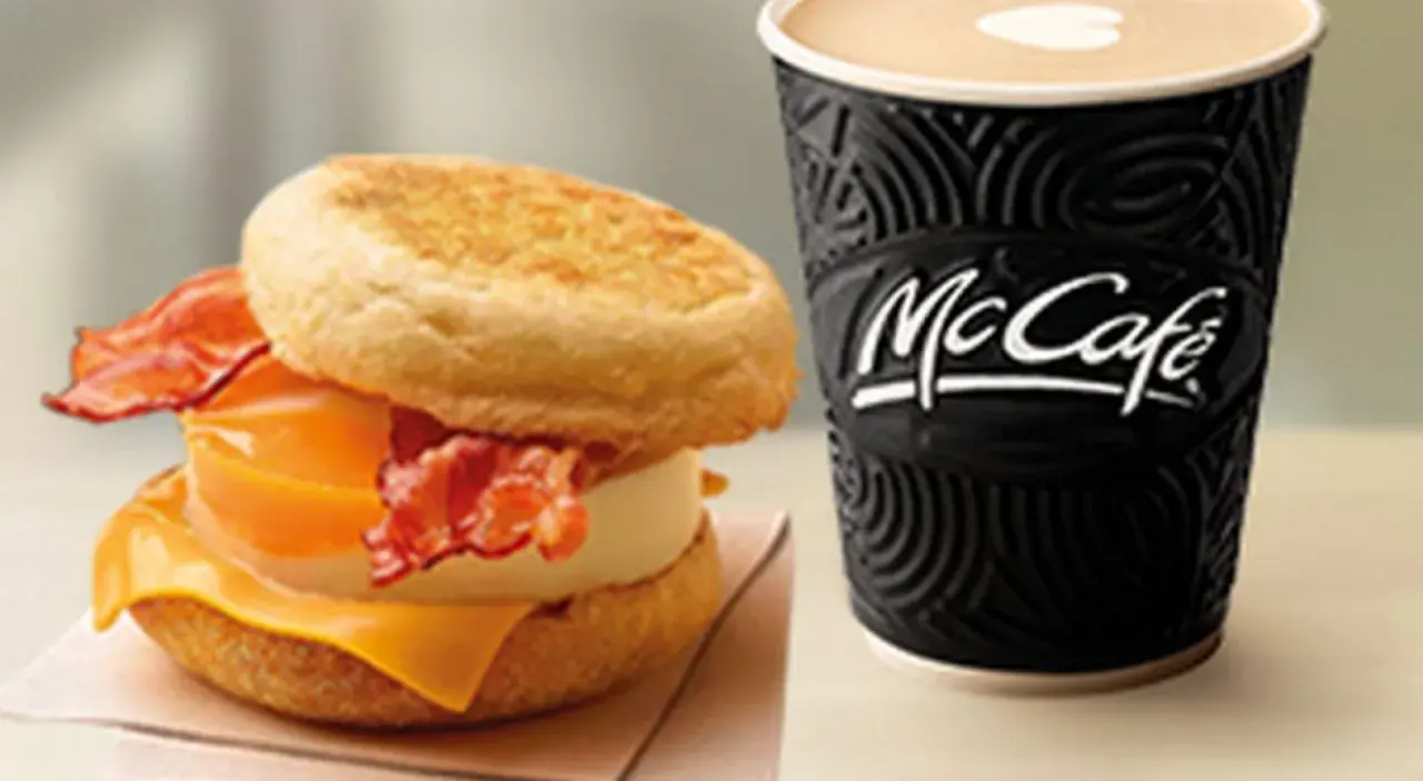 McMuffin z jajkiem, serem i bekonem obok kubka McCafe. Idealny zestaw na śniadanie.