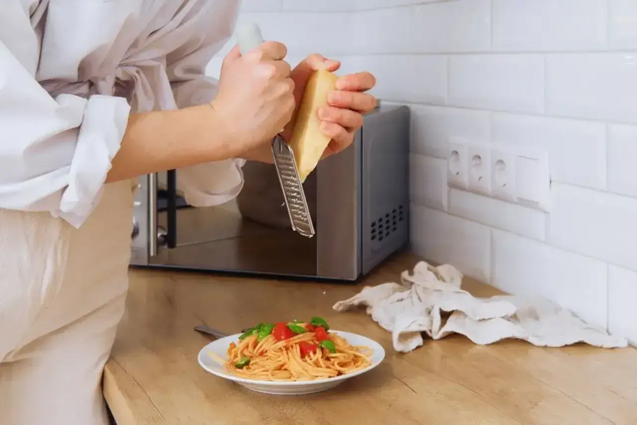 Szybki obiad? Zobacz, jak ugotować makaron w mikrofali i posypać go parmezanem.