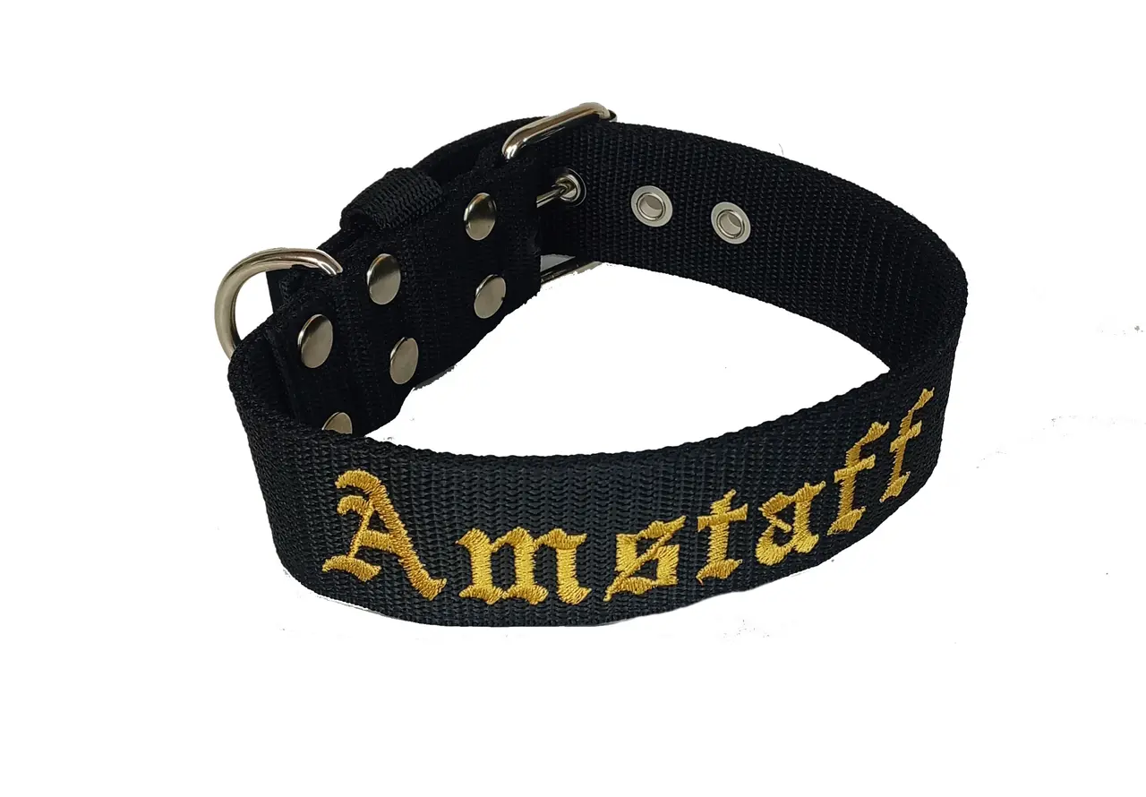 Czarna obroża dla amstaffa z haftowanym napisem "Amstaff" w kolorze złotym. Solidne metalowe okucia.