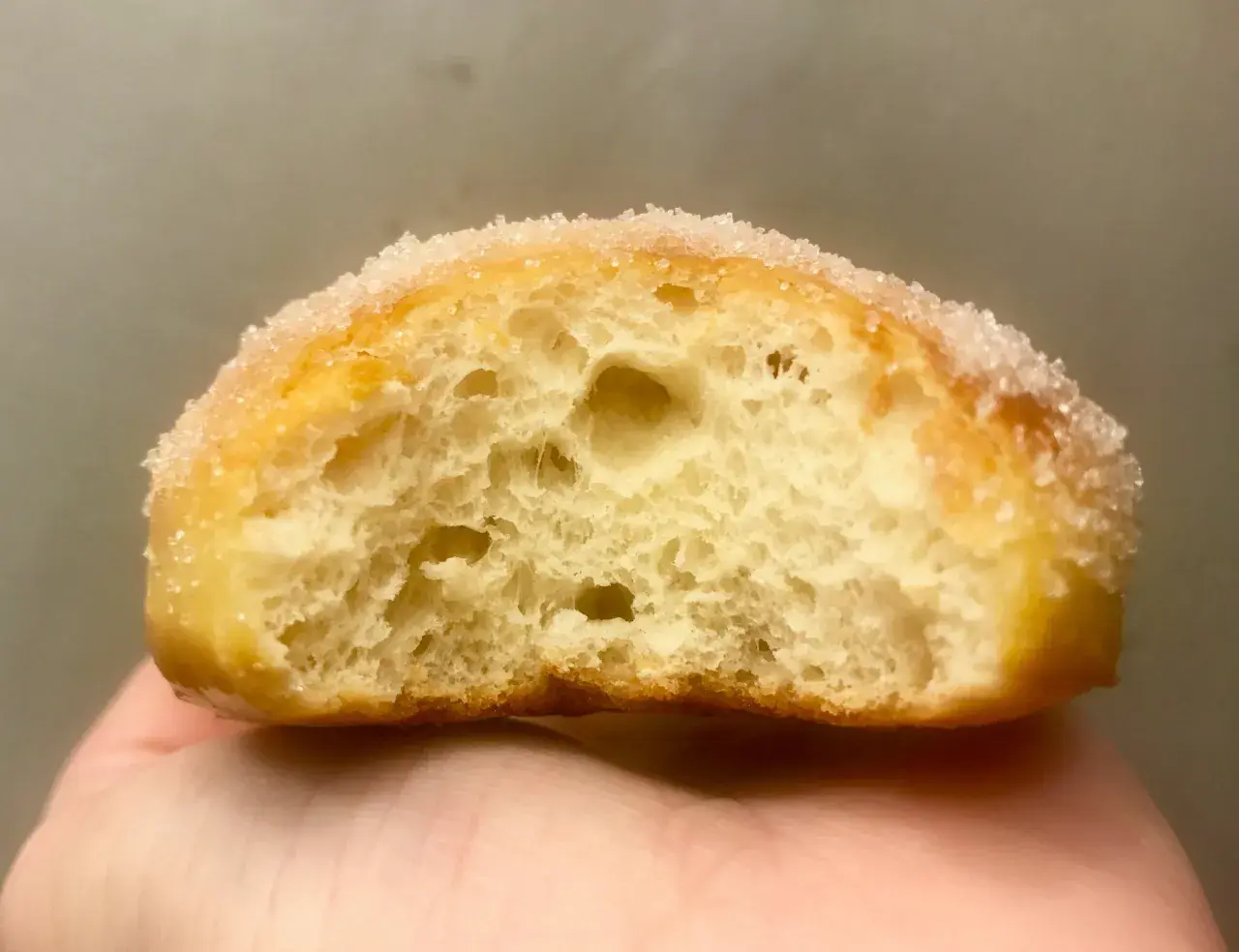 Gros plan d'un beignet sucré, sa mie aérée parfaite pour une recette beignet maison.