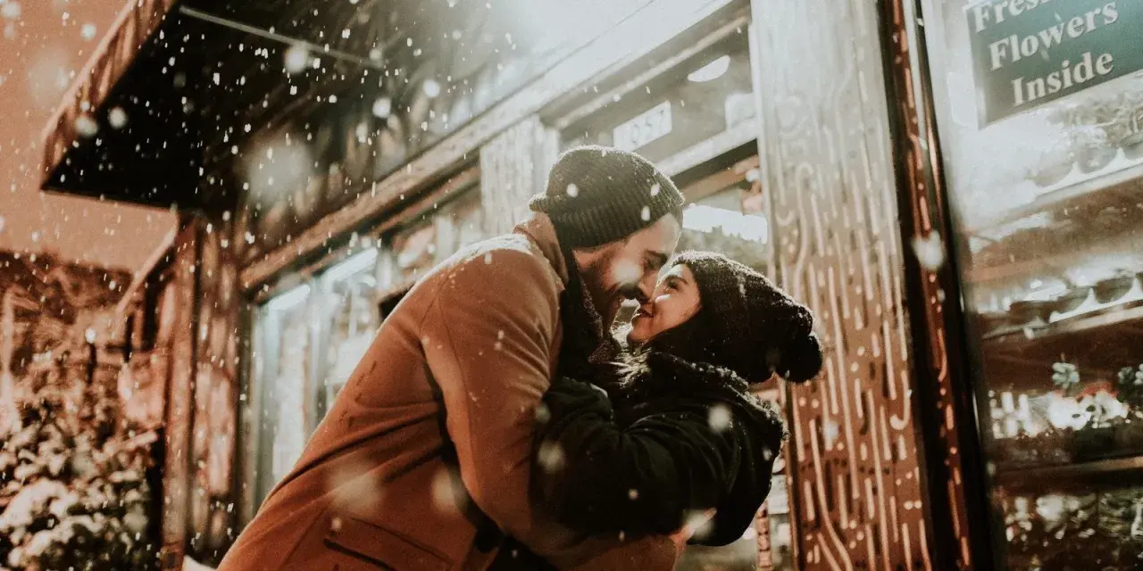 Coppia che si abbraccia sotto la neve, con lui che la guarda intensamente. Se lui non ti desidera, non ti ama.