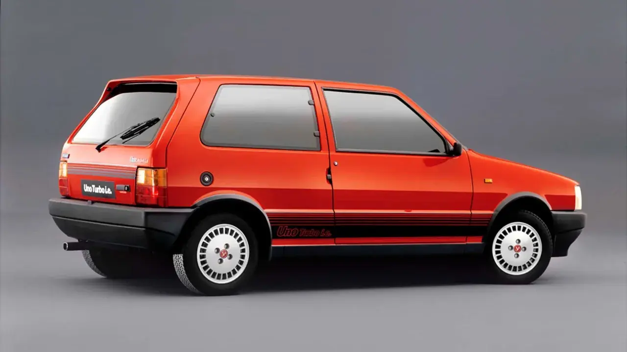 Pomarańczowy Fiat Uno Turbo Le. z czarnymi pasami na boku i felgami w stylu retro.