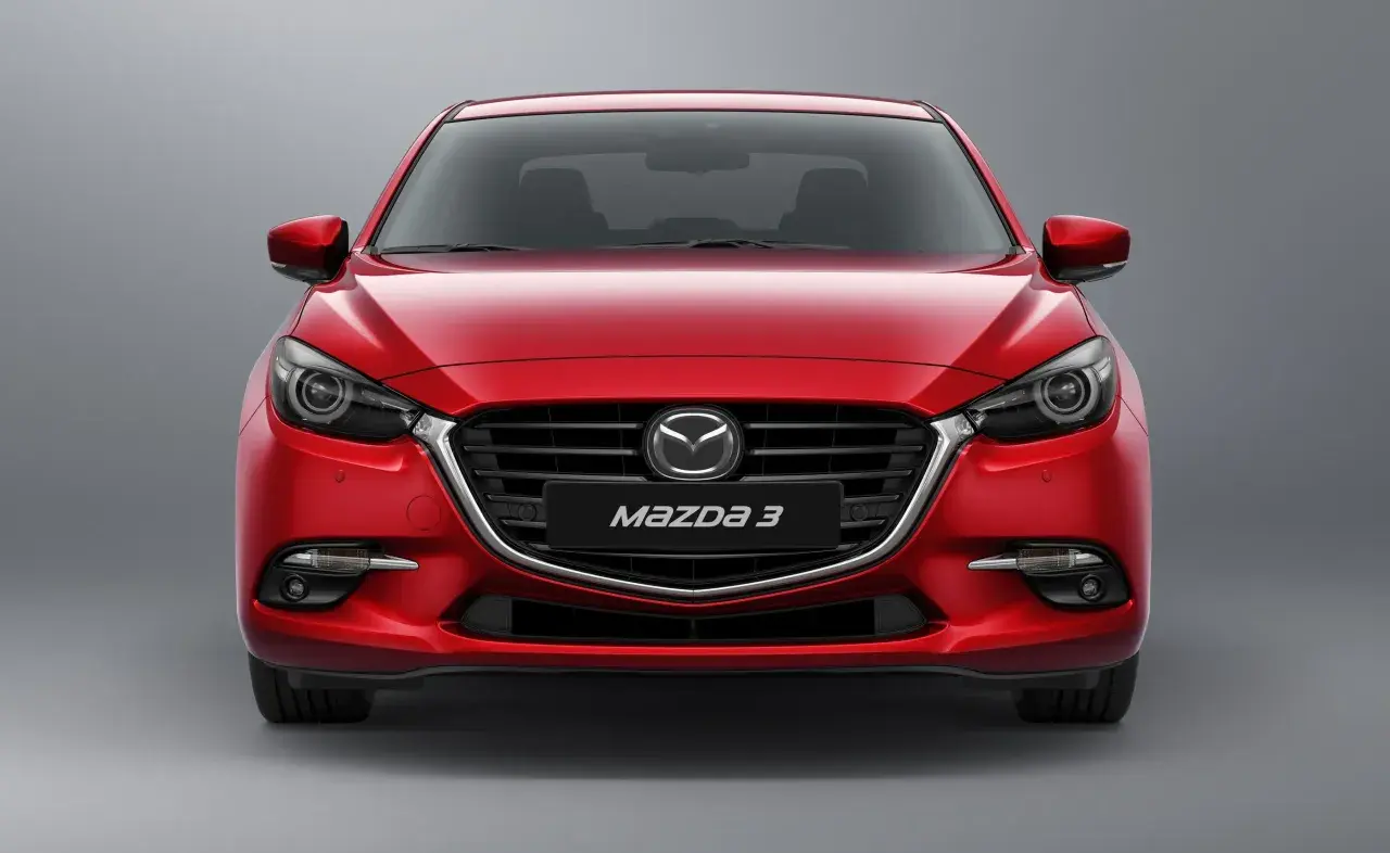 Czerwona Mazda 3 BN z przodu, z błyszczącym grillem i reflektorami.