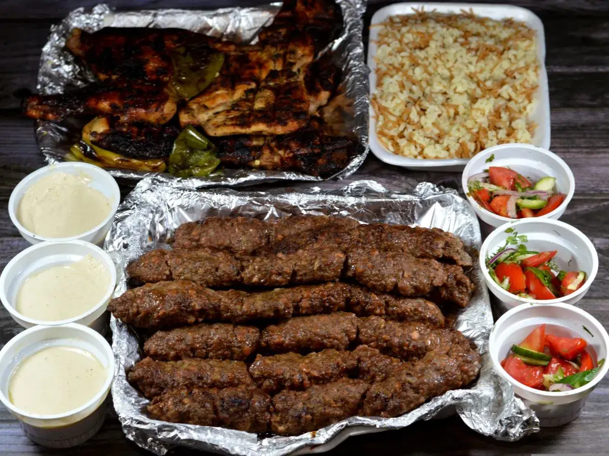 Pyszny kofta kebab z ryżem, sałatkami i sosami.