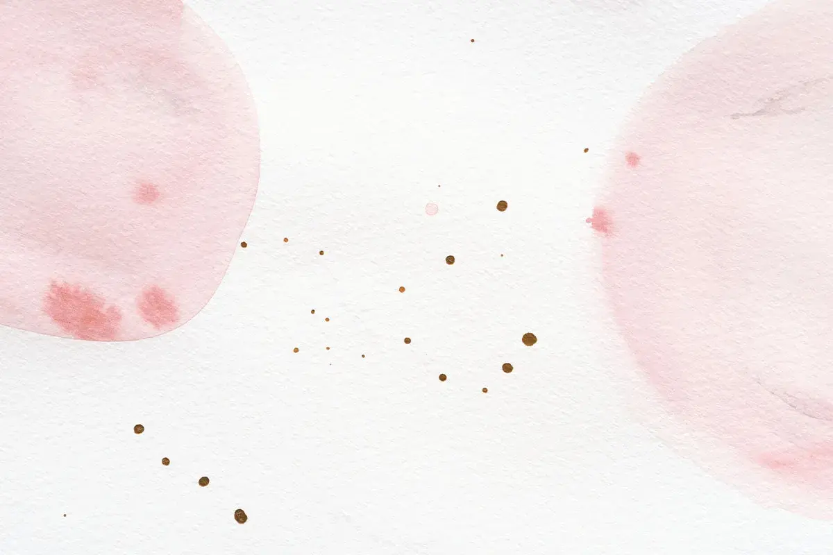 Sanfte Aquarellkreise in Rosa und Weiß mischen sich. Kleine goldene Tupfer verteilen sich auf dem Papier.