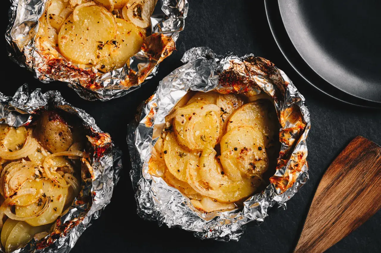 Pommes de terre en papillote, idéales pour un barbecue au gaz. Savoureuses et tendres, elles sont prêtes à être dégustées.