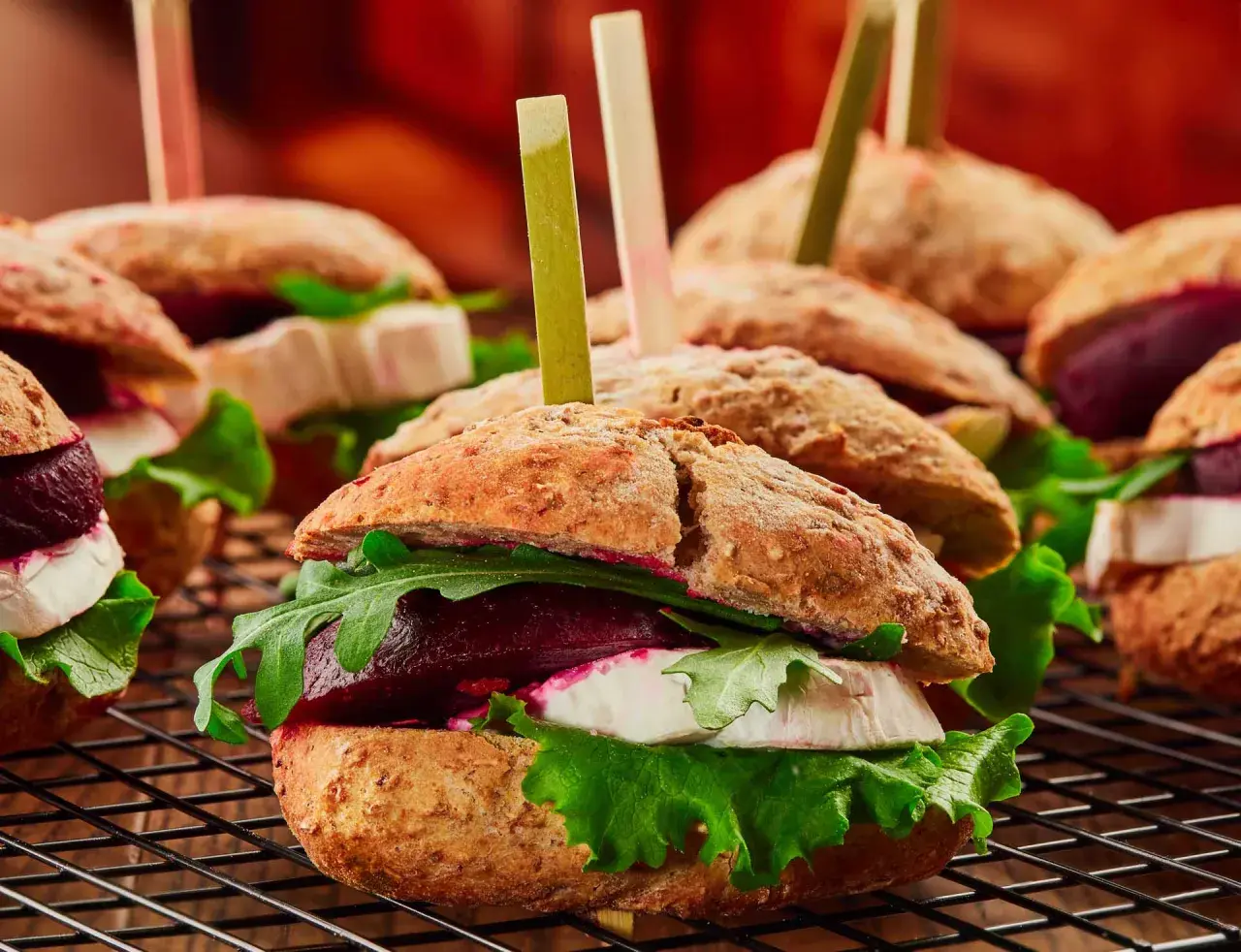 Mini burgery z burakiem, serem kozim i rukolą. Apetyczna fotografia kulinarna.