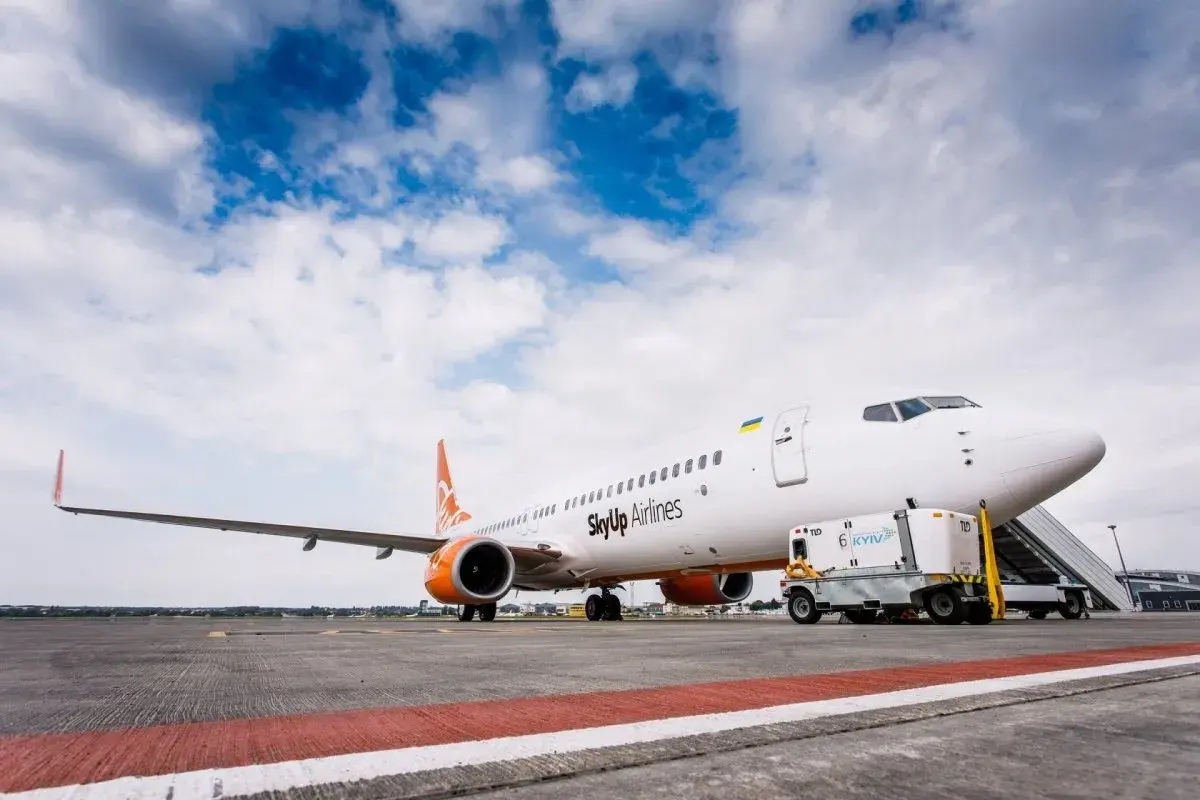 Samolot SkyUp Airlines gotowy do startu. W tle błękitne niebo z chmurami.