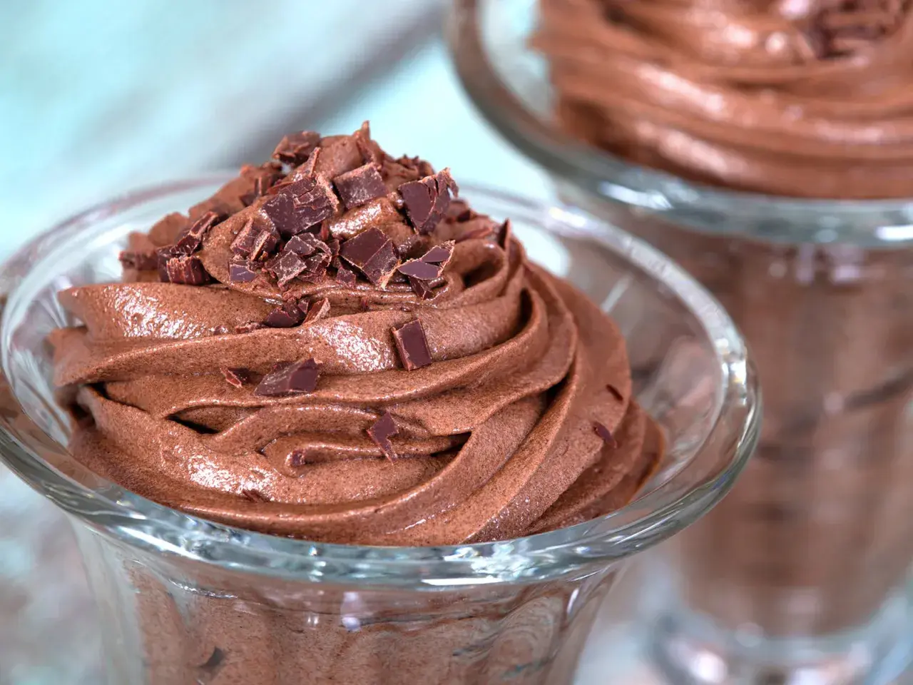 Zarte Mousse au Chocolat, gekrönt mit Schokoladenstückchen, in einem Glas serviert. Ein Genuss für Schokoladenliebhaber.