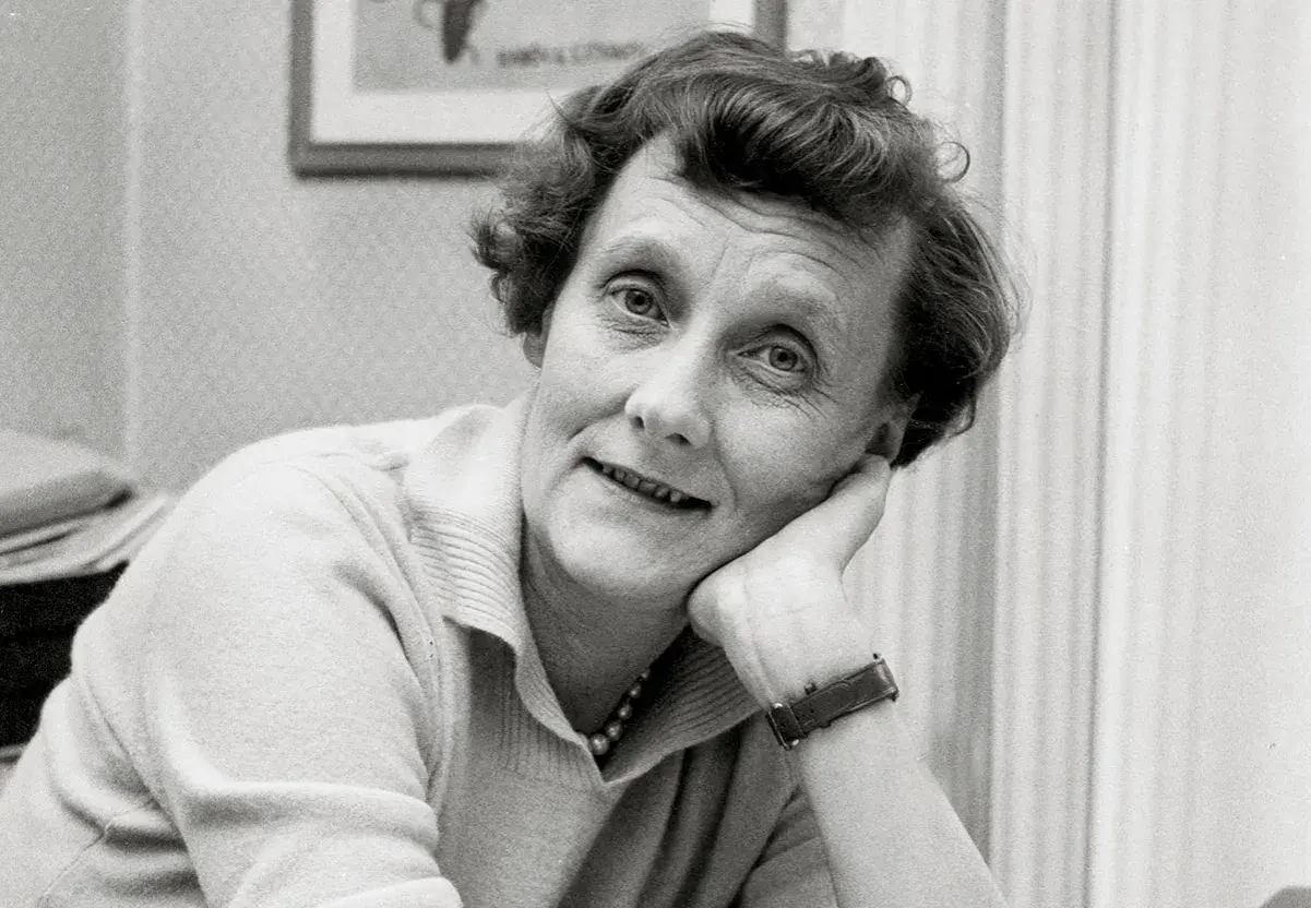 En ung Astrid Lindgren lutar sig mot sin hand, med ett drömmande uttryck.