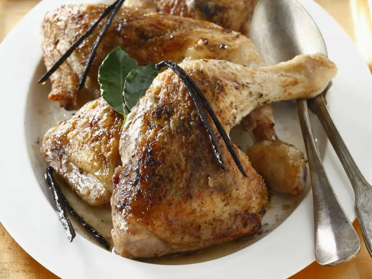 Cuisses de chapon dorées, nappées d'une sauce savoureuse, garnies de gousses de vanille et de feuilles de laurier. Une invitation à découvrir la recette de cuisses de chapon en sauce.