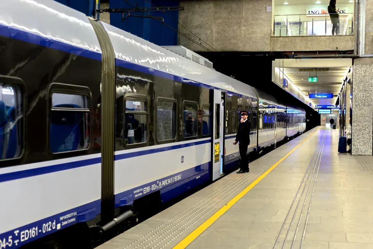 Konduktor PKP Intercity czeka na peronie, gotowy do odjazdu. Trasa IC Malczewski wyrusza w podróż.