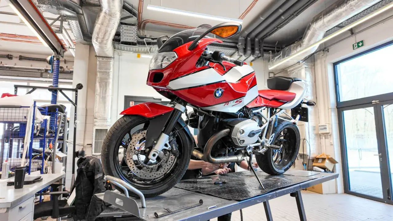 Czerwono-biały motocykl BMW R1200S na podnośniku w warsztacie.