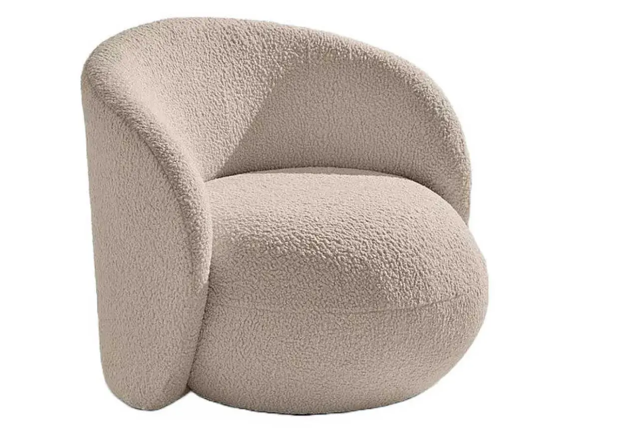 En mjuk och inbjudande teddyfåtölj i ljusbeige färg, perfekt för mysiga hemmakvällar.