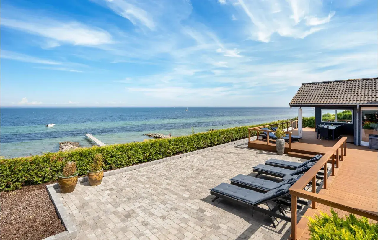 Traumhafter Blick auf den Lohme Strand mit Liegen auf der Terrasse und dem Meer im Hintergrund.