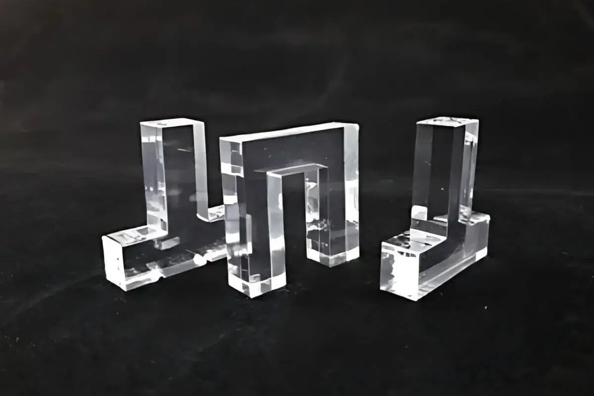 Tre forme geometriche trasparenti, realizzate in materiale acrilico, su sfondo nero.