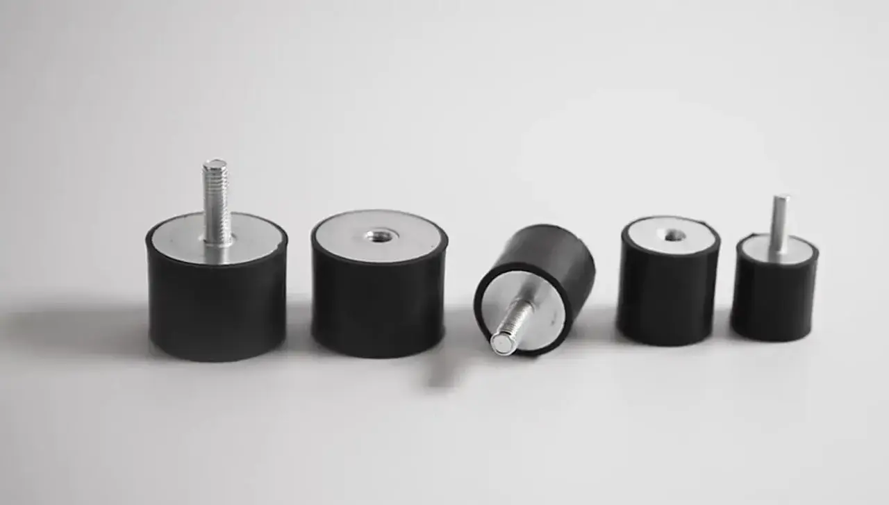 Cinco silentblocks de coche, algunos con tornillo, otros con rosca. Un silentblock roto, listo para ser reemplazado.