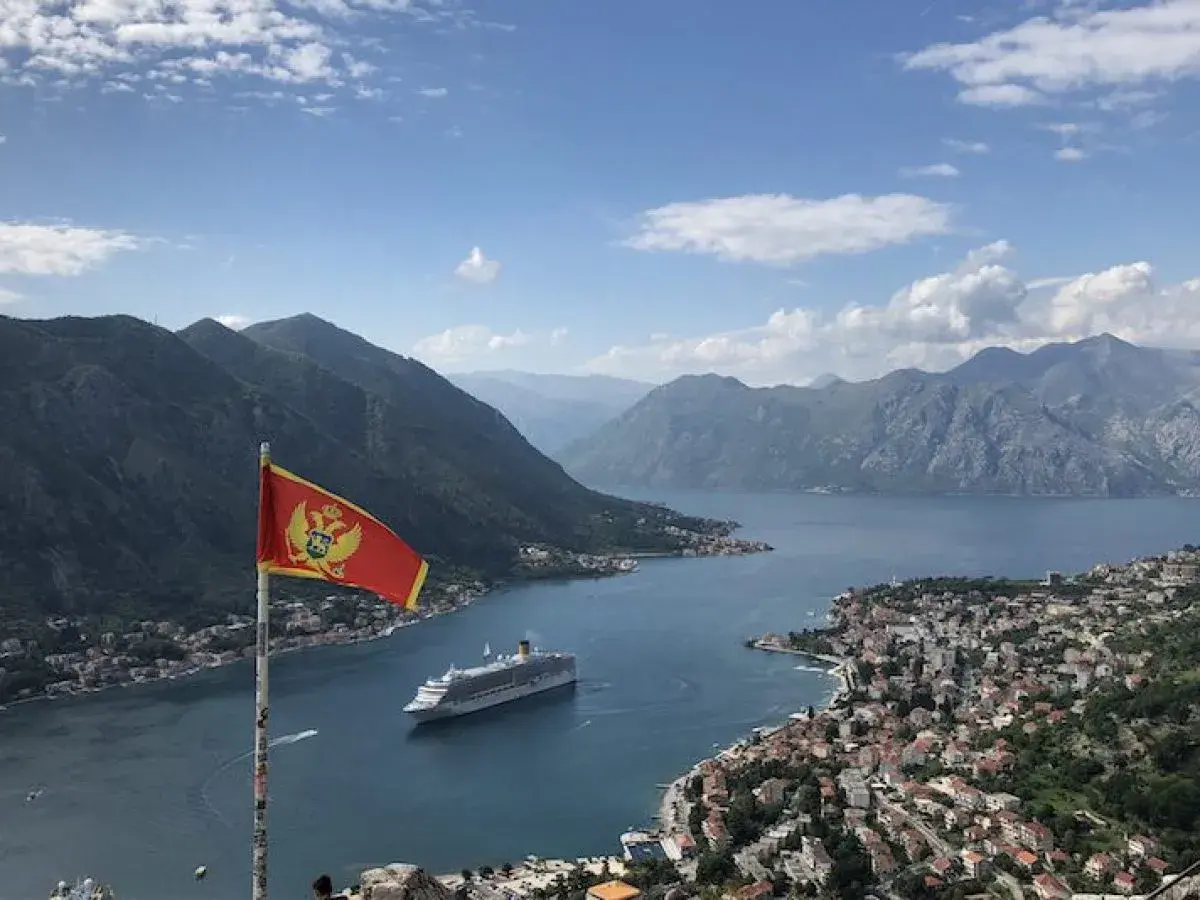 Montenegro backpacking: Fahne weht über Bucht mit Kreuzfahrtschiff und Bergen. Traumhafter Ausblick!