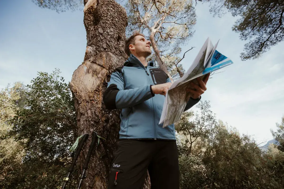 Un randonneur consulte une carte IGN pour s'orienter. C'est quoi une carte IGN ? C'est l'outil indispensable pour explorer la nature.