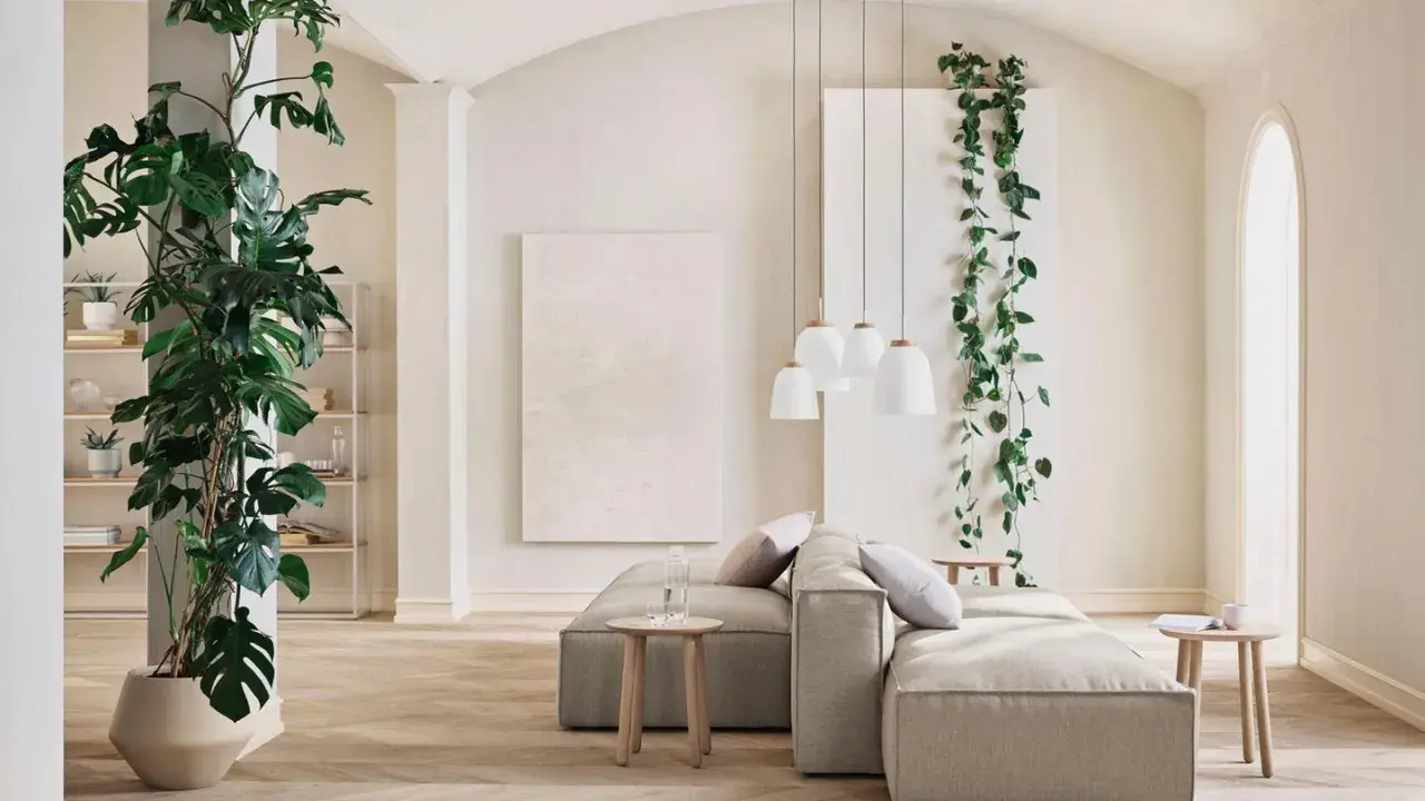 Ein großes, rankendes Zimmerpflanzen-Ensemble umrahmt eine gemütliche Wohnzimmerecke mit einem beigen Sofa und Hängeleuchten.