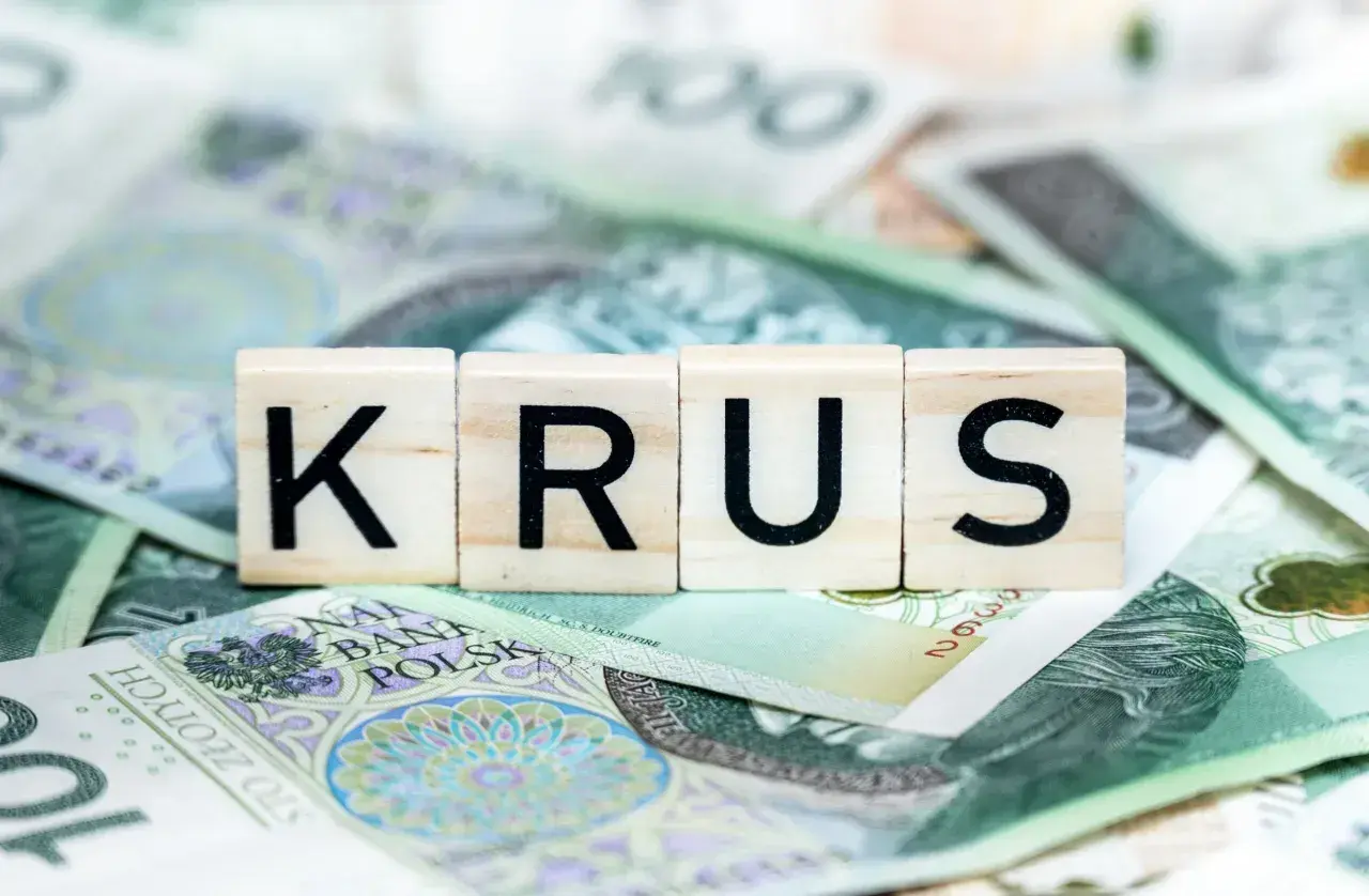 Litery KRUS ułożone na banknotach 100 zł. To symbol oszczędności na emeryturę z KRUS.