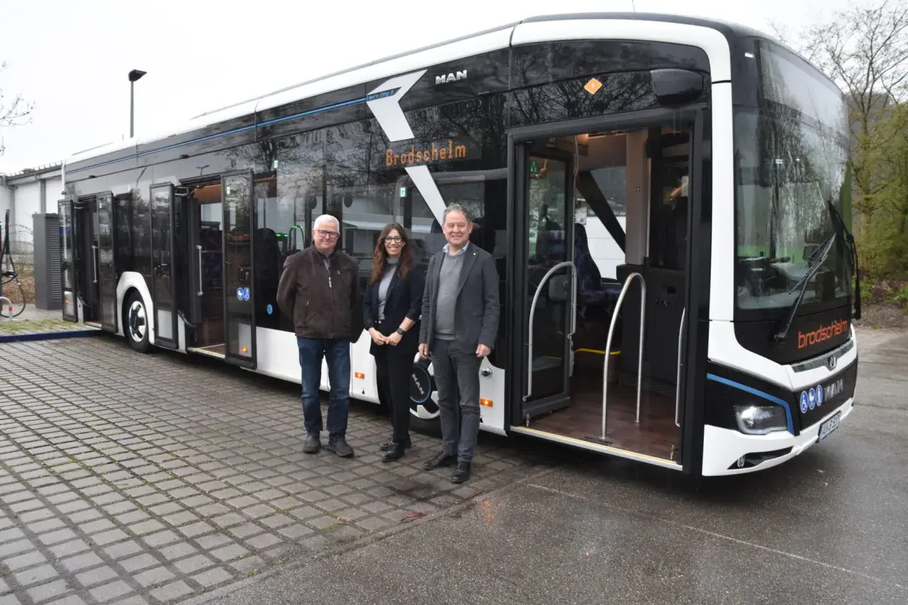 Drei Personen stehen vor einem modernen elektro bus mit der Aufschrift "Brodscheim".