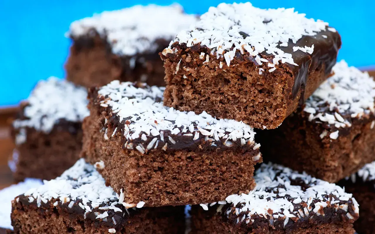 En hög med saftiga kärleksmums utan mjölk, toppade med chokladglasyr och kokosflingor.