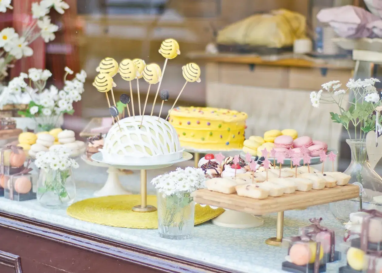 Deliciosa comida para revelación de género: pastel amarillo con lunares, macarons y bocadillos dulces.