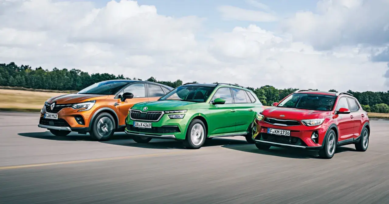Trzy miejskie crossovery: pomarańczowy Renault, zielona Skoda i czerwony Kia Stonic 2024 jadą po drodze.