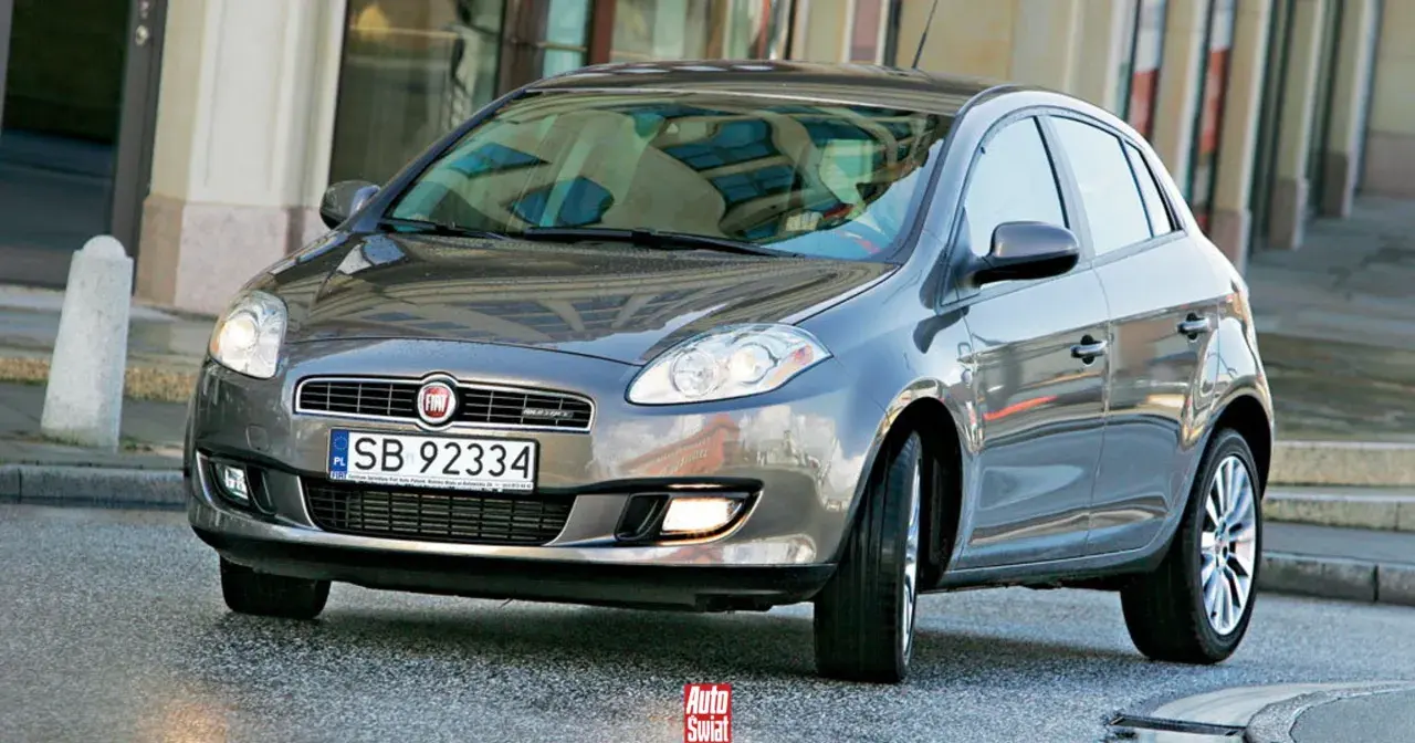 Szary Fiat Bravo 2 z tablicą rejestracyjną SB 92334 na tle budynku.
