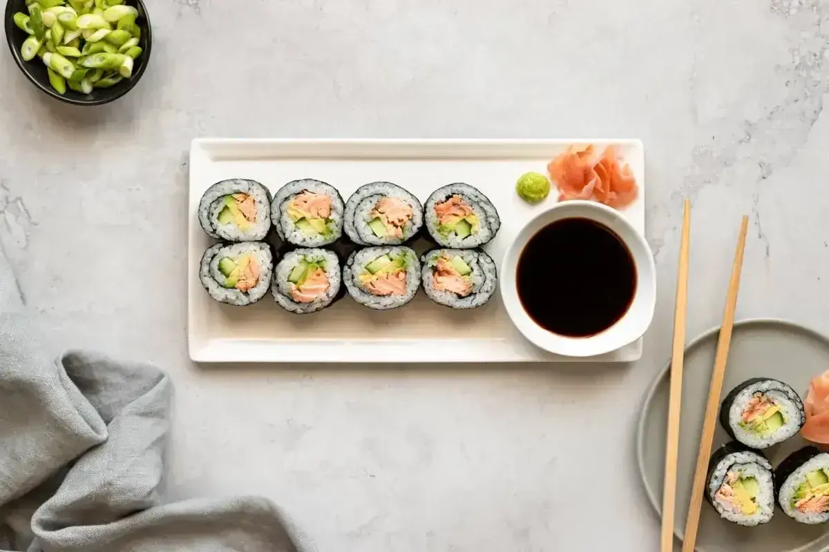 Smaczne hosomaki z łososiem i awokado, podane z sosem sojowym i wasabi.