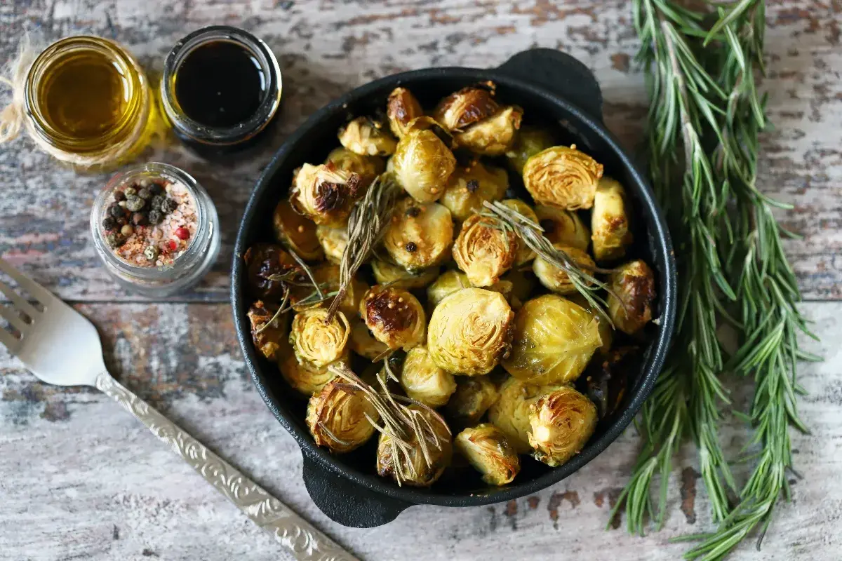 Cavoletti di Bruxelles arrostiti in padella con rosmarino, accompagnati da olio, aceto balsamico e sale aromatizzato.