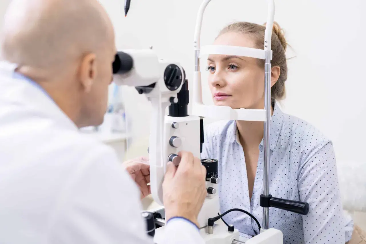 Badanie wzroku u okulisty. Pacjentka z astygmatyzmem czeka na diagnozę, czy potrzebuje okularów plusy czy minusy.