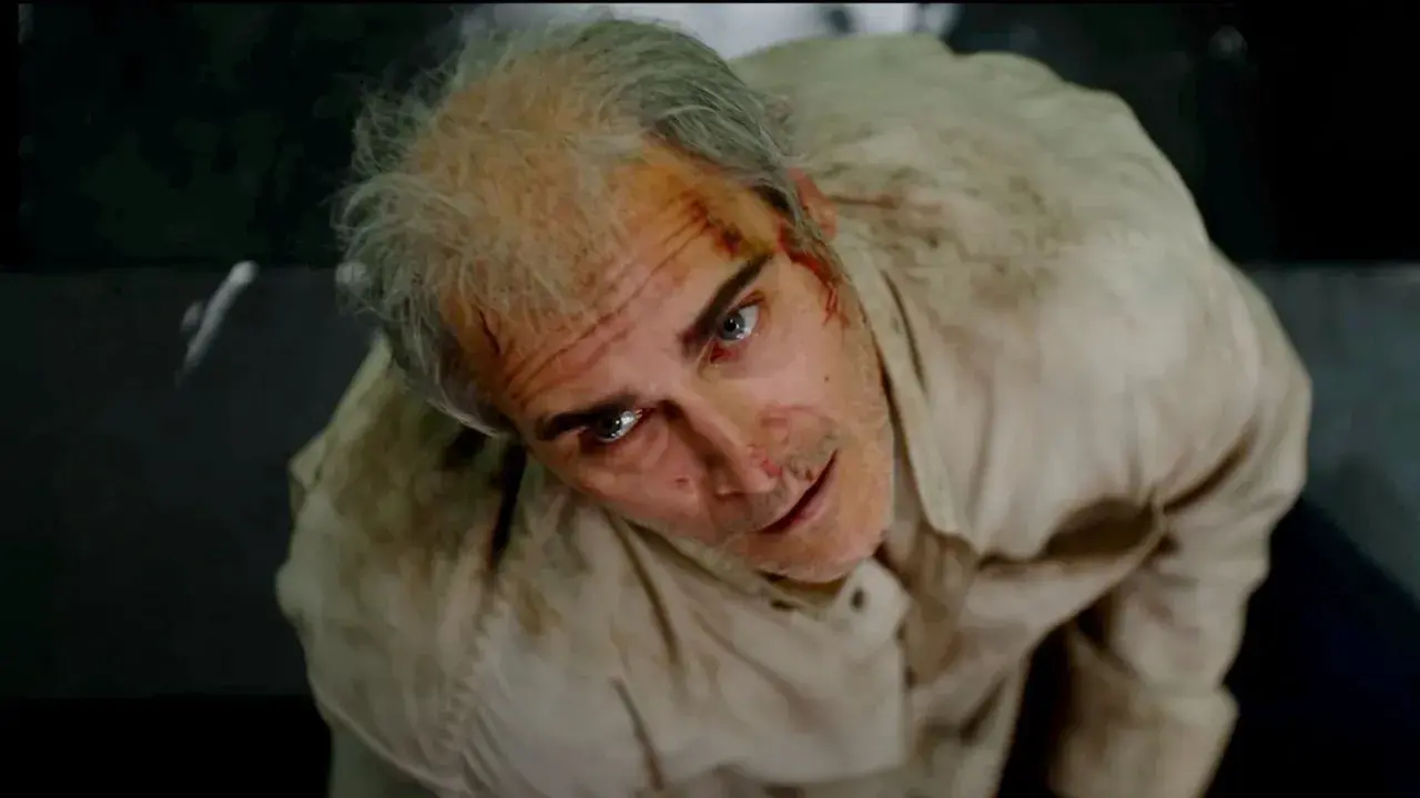 Un uomo con i capelli grigi e ferite sul viso, vestito di una camicia sporca, guarda in alto con espressione spaventata. Beau ha paura, spiegazione visiva.