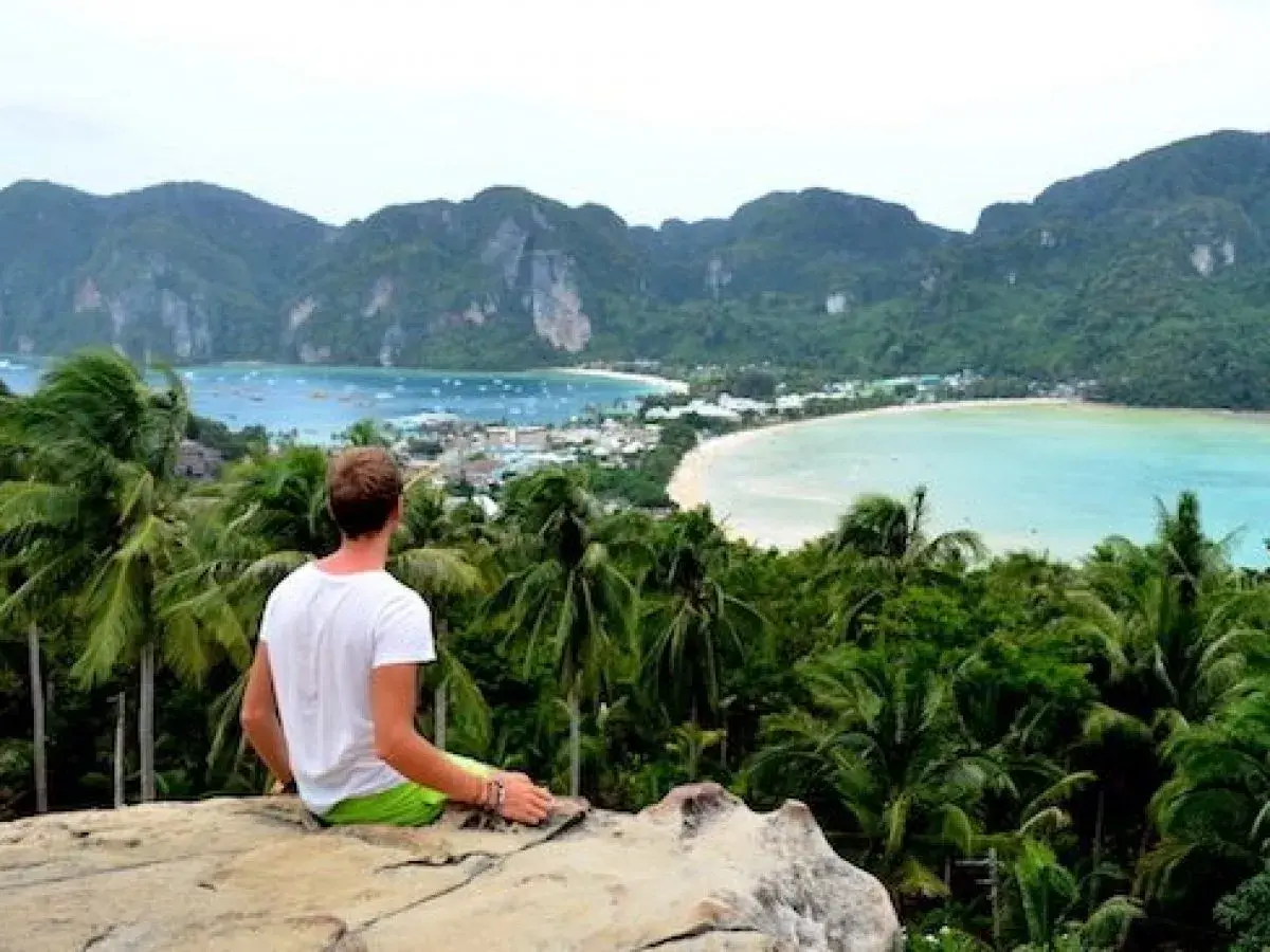 Mann genießt atemberaubenden Blick auf Bucht in Thailand. Tolle Thailand Urlaub Tipps für unvergessliche Momente.