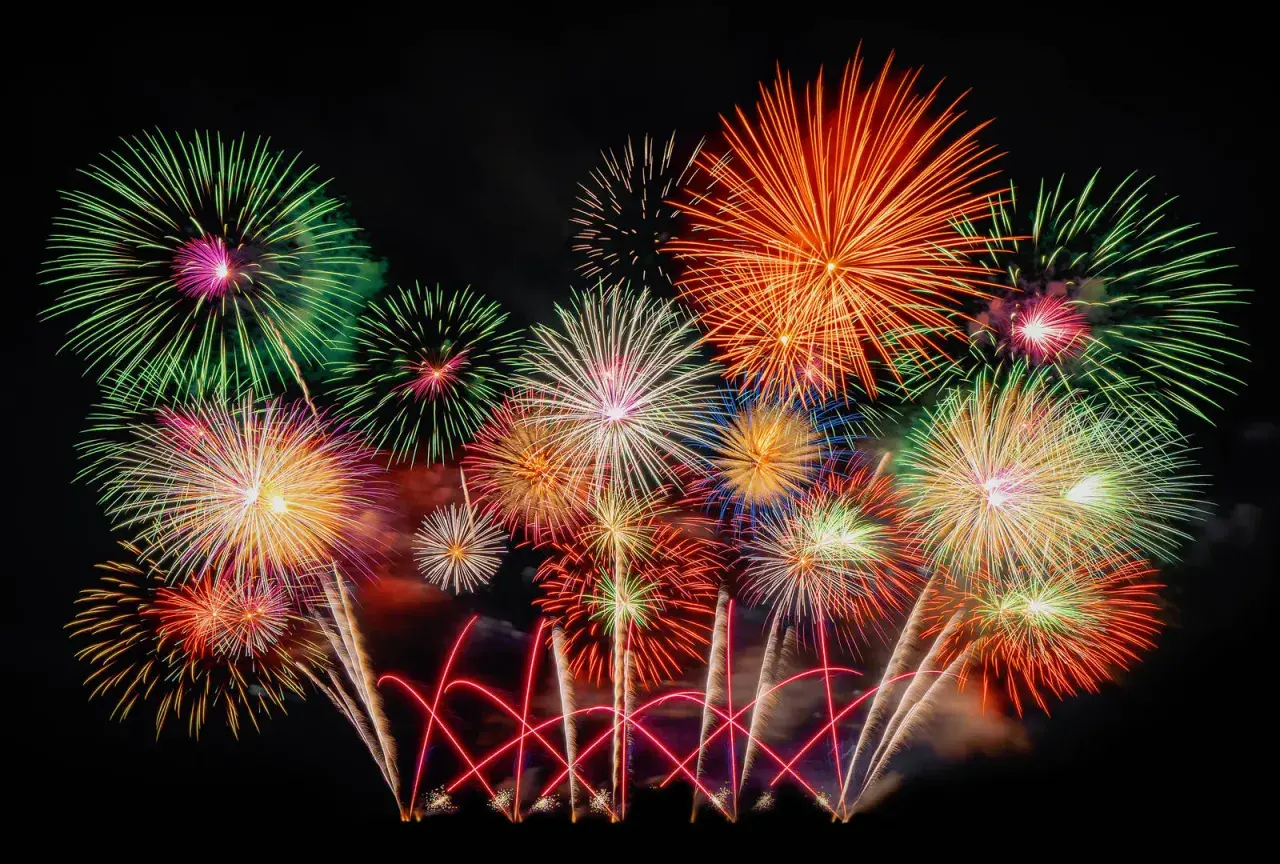 Ein farbenprächtiges Feuerwerk erhellt den Nachthimmel, wie es typisch für Silvester in Deutschland ist.