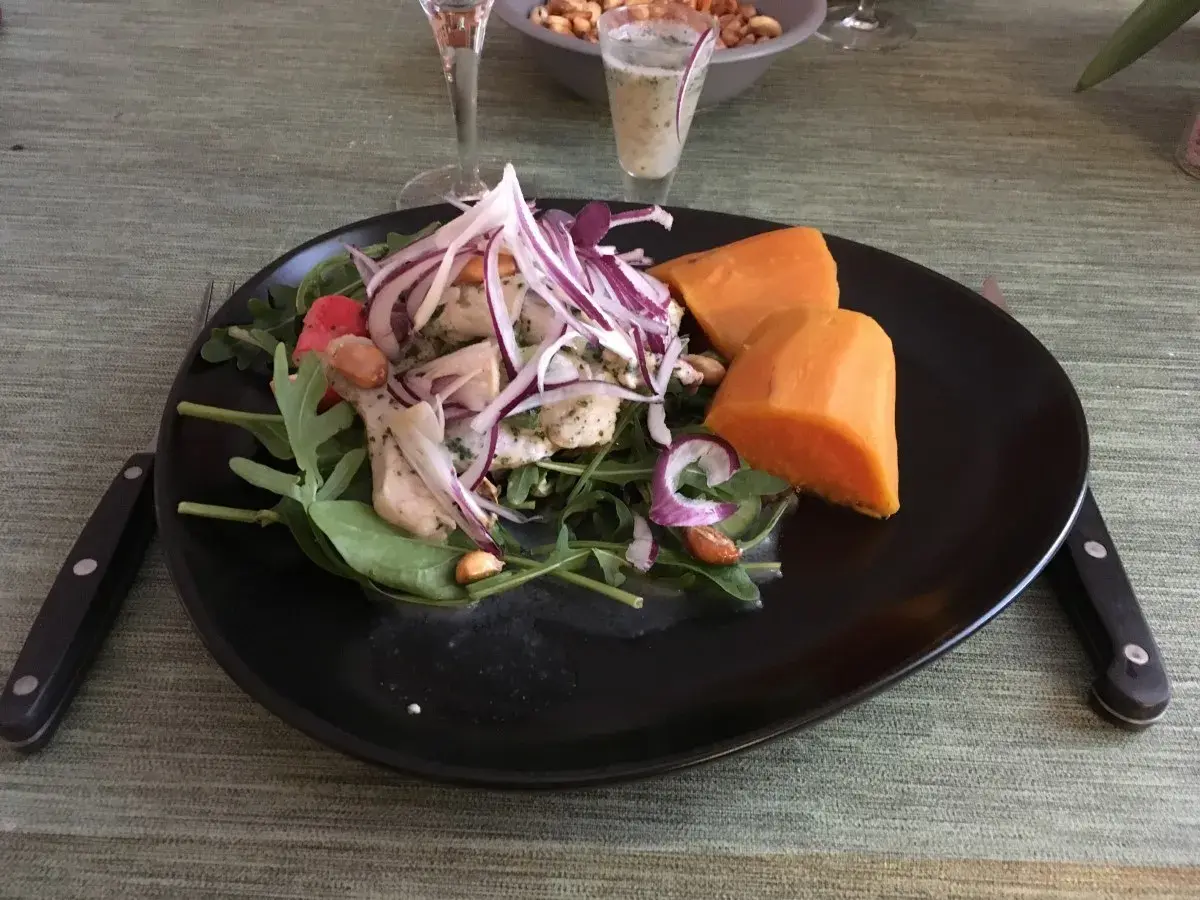 En tallrik med ceviche, sötpotatis och grönsaker. Fisken är marinerad i leche de tigre, en syrlig och smakrik citrusmarinad.
