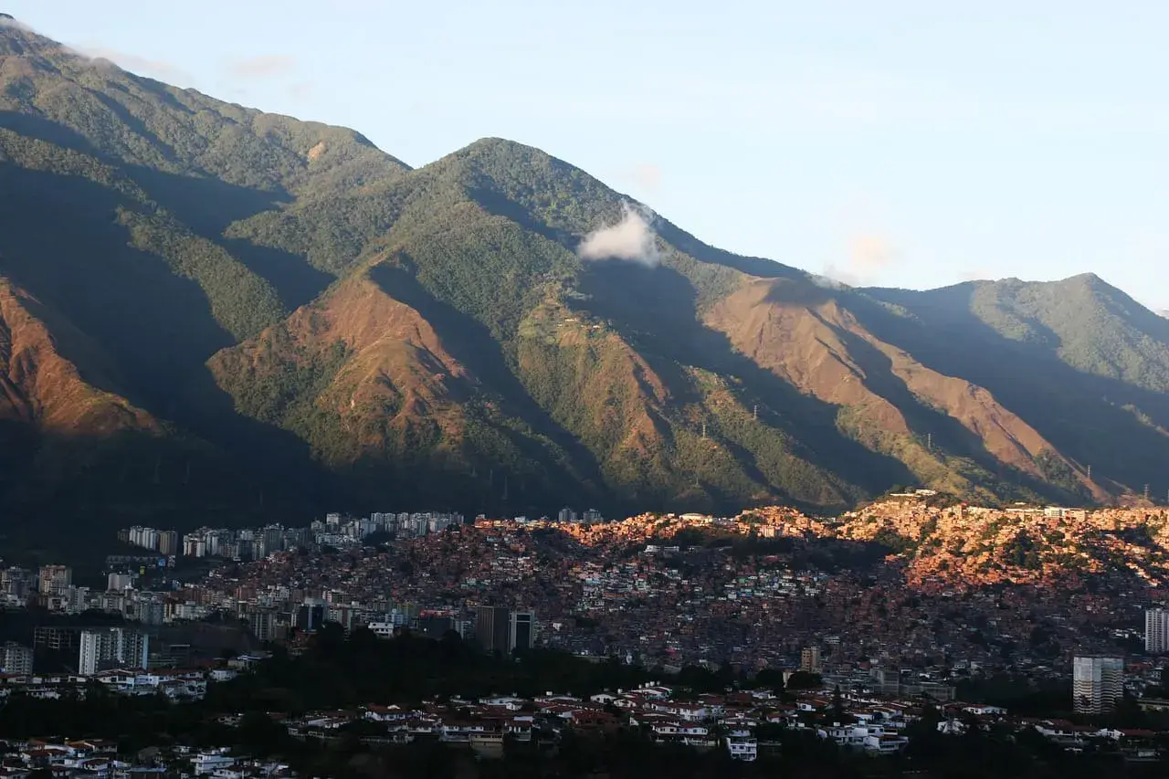 Góry otaczają Caracas, stolicę Wenezueli. Widać gęsto zabudowane wzgórza i nowoczesne budynki.