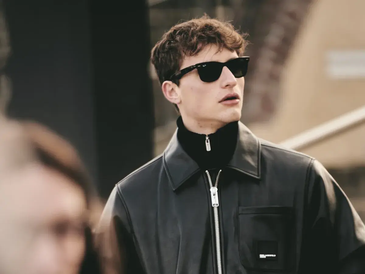 Joven con gafas de sol y chaqueta de cuero, luciendo modernos cortes de pelo hombre joven.