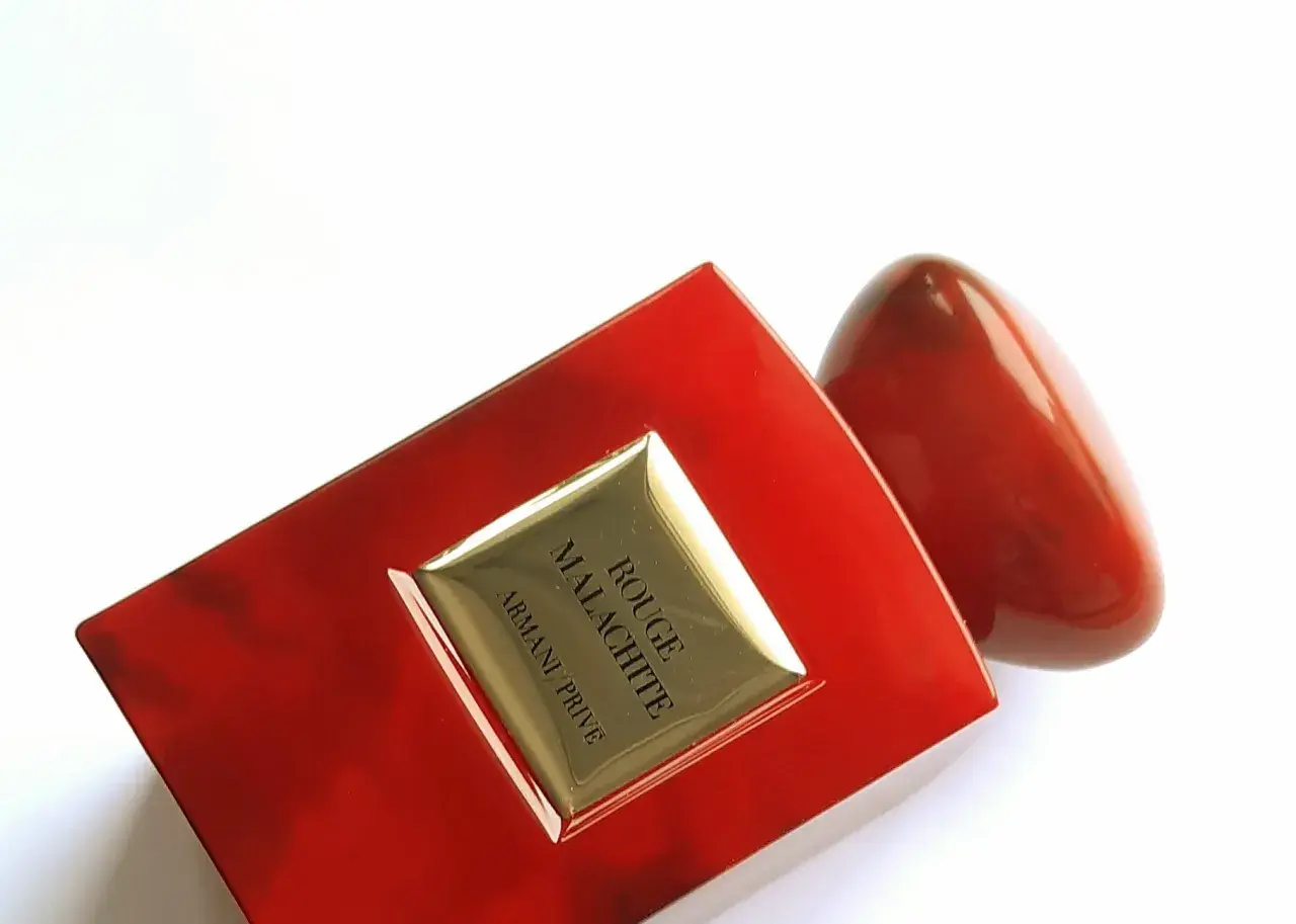 Luksusowe perfumy Armani Privé Rouge Malachite w czerwonym, błyszczącym flakonie, przypominającym kamień.