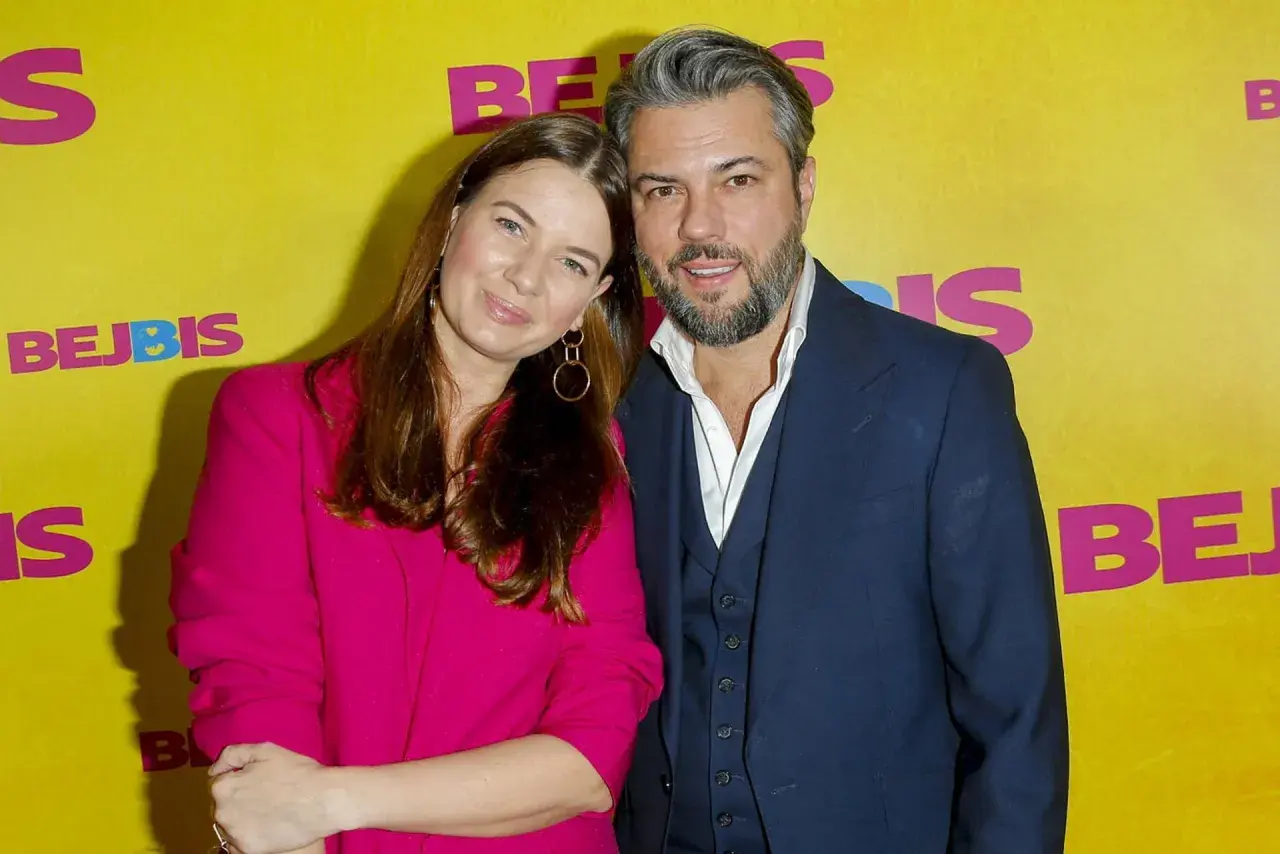 Karolina Malinowska Janiak i jej partner pozują na tle żółtej ścianki z napisem "BEJBIS".