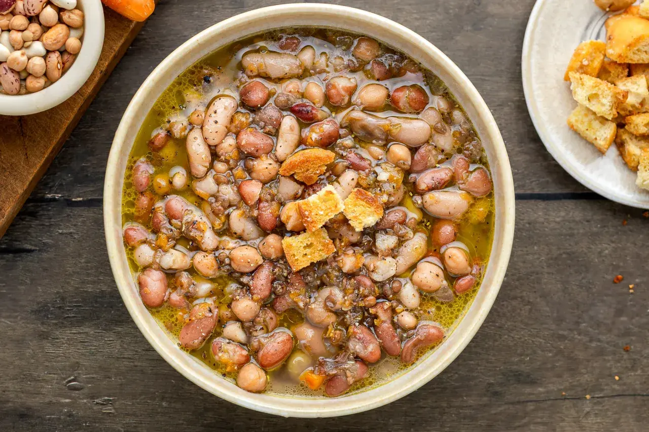 Una ciotola fumante di zuppa di legumi, ricca e saporita, con crostini dorati.