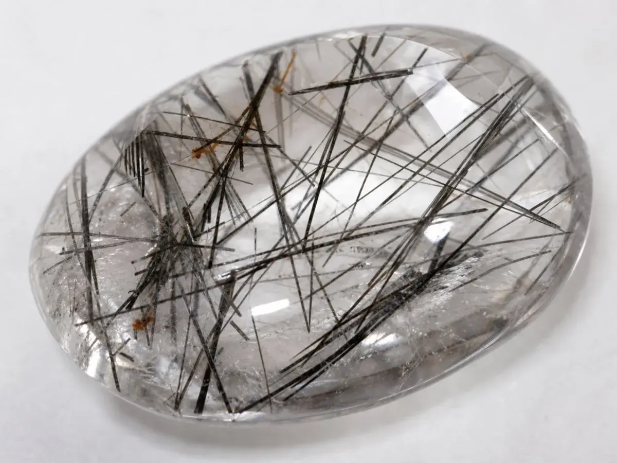 Cuarzo rutilado propiedades: piedra transparente con inclusiones negras y doradas, como un bosque de agujas.