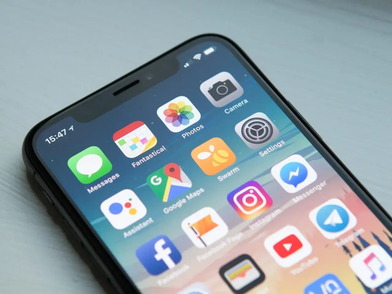 Ekran smartfona z ikonami popularnych aplikacji: Messages, Fantastical, Photos, Camera, Google Maps, Swarm, Settings, Assistant, Instagram, Messenger, Facebook, YouTube, Telegram.