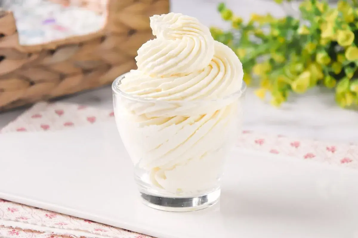 Delicioso frosting de queso cremoso, decorado en espiral, servido en un vaso de vidrio.