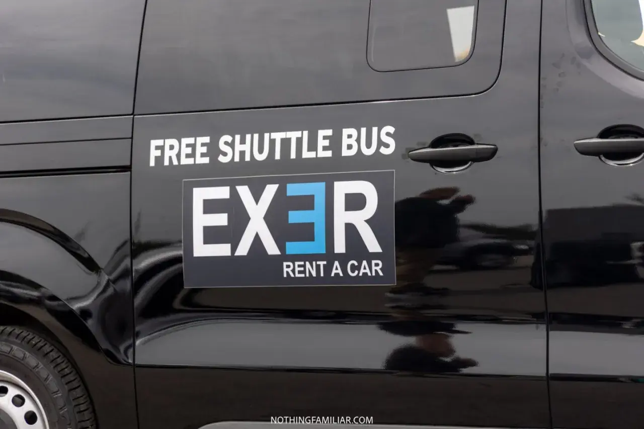 Black shuttle bus with "EXER RENT A CAR" logo. Considering whether to rent a car in Athens? This shuttle might be a good option.