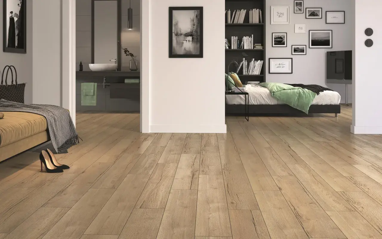 Drewnopodobne, jednakowe płytki w całym domu tworzą spójną i przytulną przestrzeń. Widać fragment sypialni i łazienki.