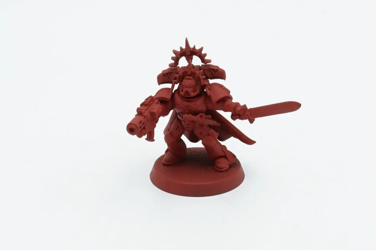 Czerwona figurka kosmicznego marine z mieczem i bolterem, gotowa do walki jako jeden z legendarnych Blood Angels.